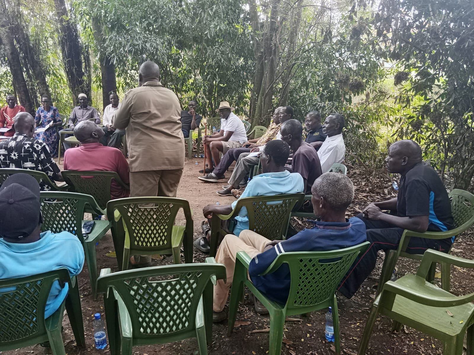 Community discussion taking place beneath trees