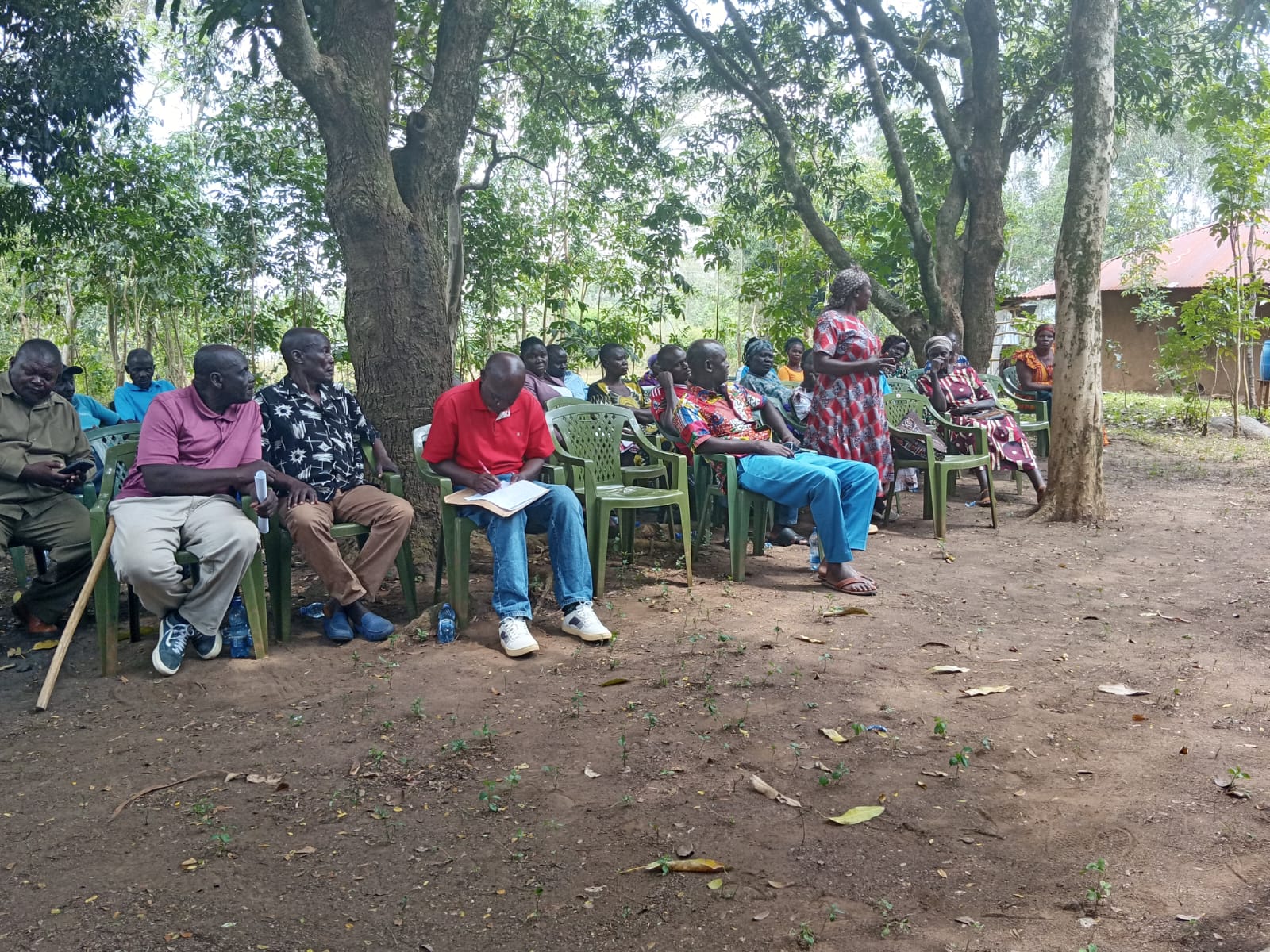 A woman speaking before seated community members
