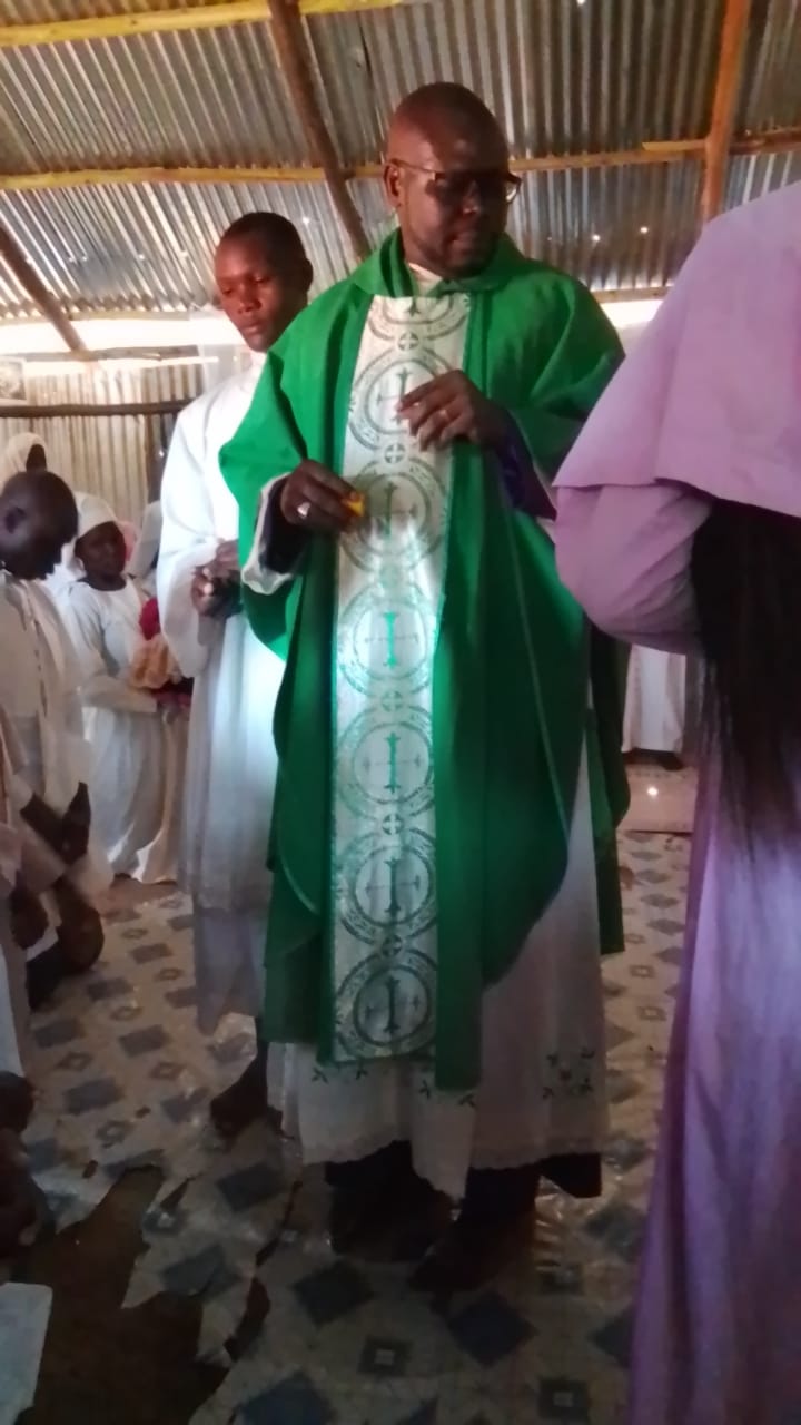 Rev. Father Willis Ondiek in green vestments during ministry
